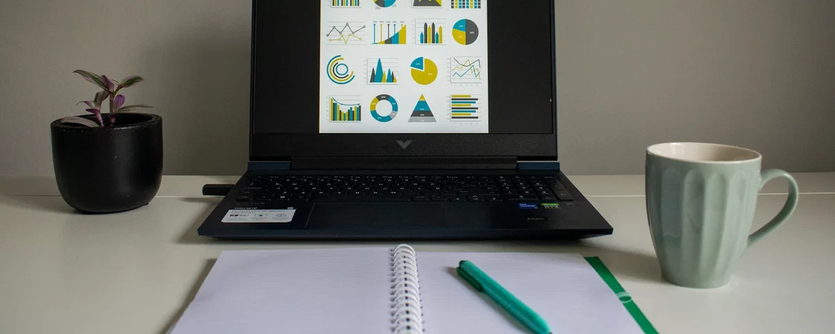 A data analysis workspace with charts displayed on a laptop